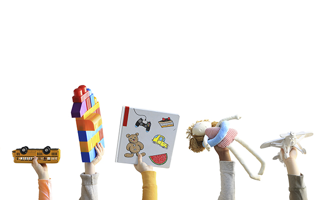 kids holding up toys and books
